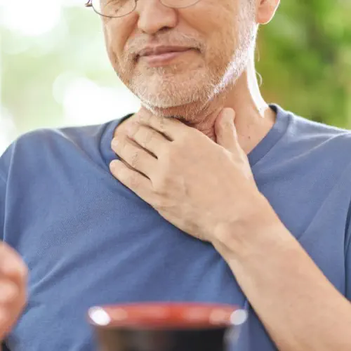 A man is holding his throat showing signs of choking